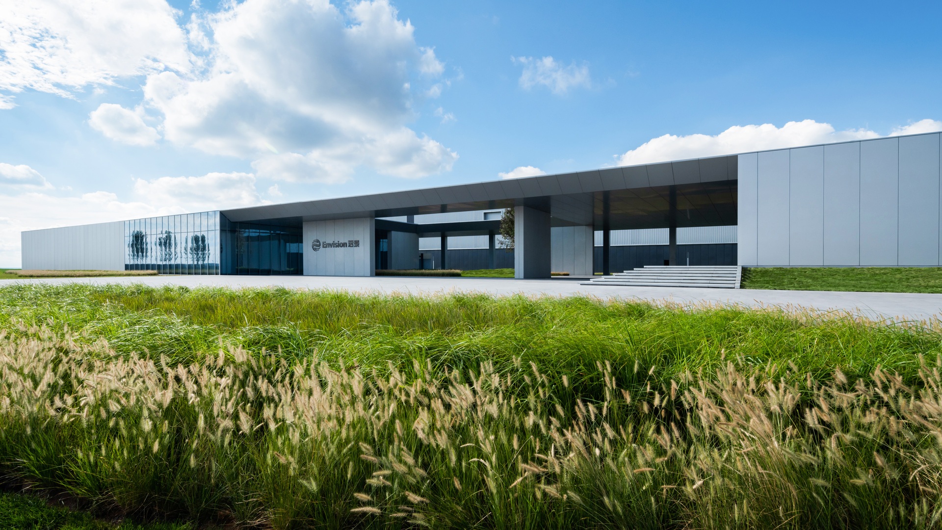 High-tech building with expansive glass façades, flat roof, and sustainable landscaping, designed for advanced research and innovation.
