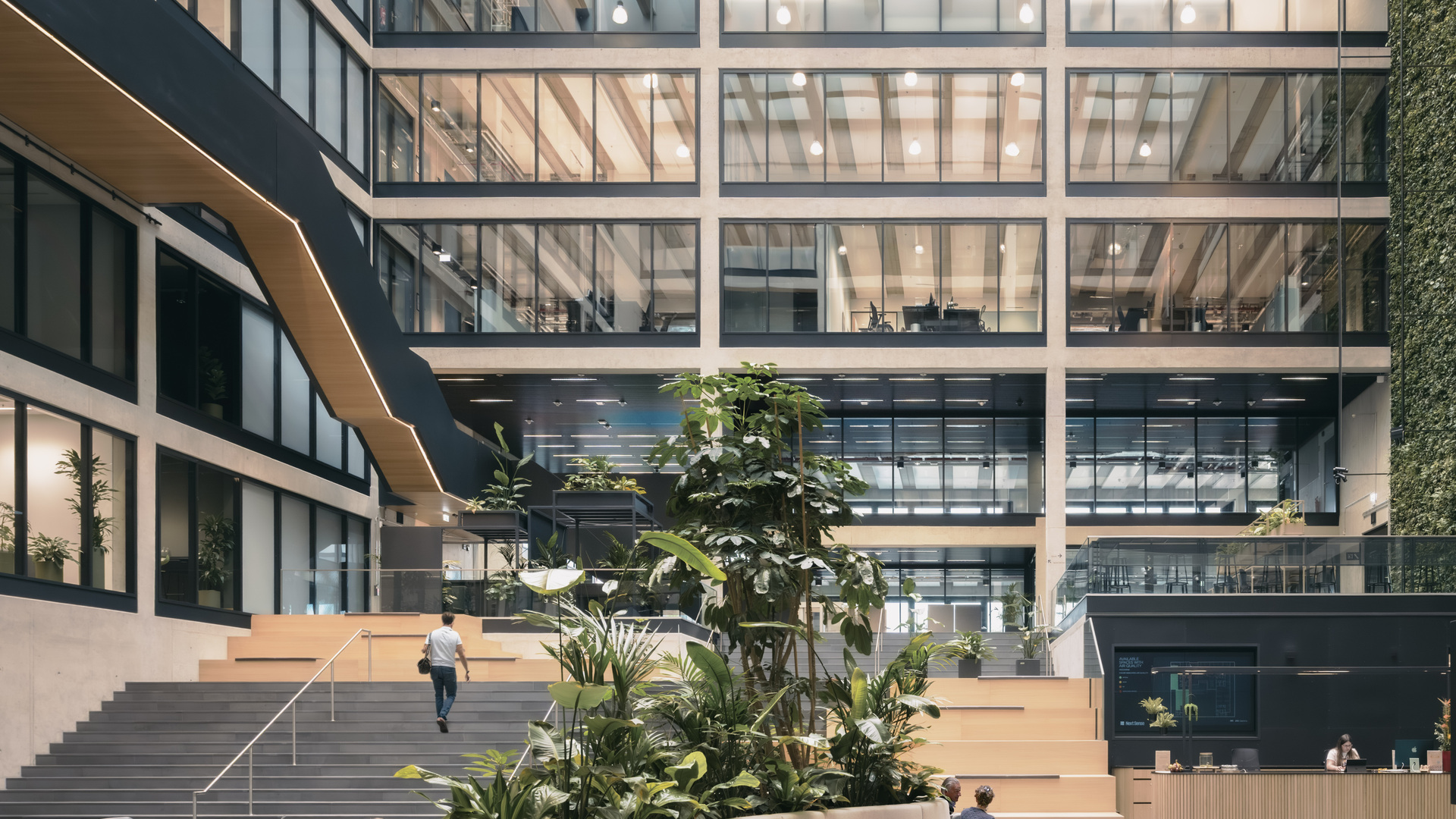 High-tech atrium with modular seating, integrated greenery, collaborative zones, and sustainable design for research and innovation.