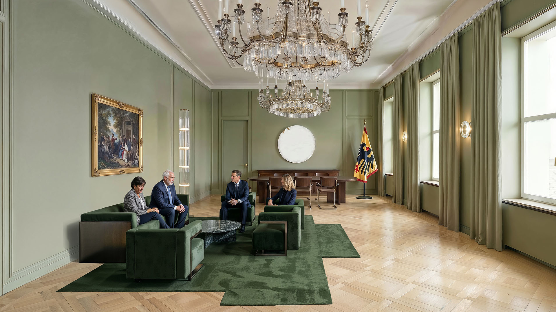 Four people engage in discussion within a sophisticated meeting space designed for collaboration, featuring expansive windows for optimal natural light, modular green seating, intelligent lighting systems resembling chandeliers, and interior details that showcase advanced sustainable materials—highlighting a purposeful environment focused on innovation and high-performance architecture.